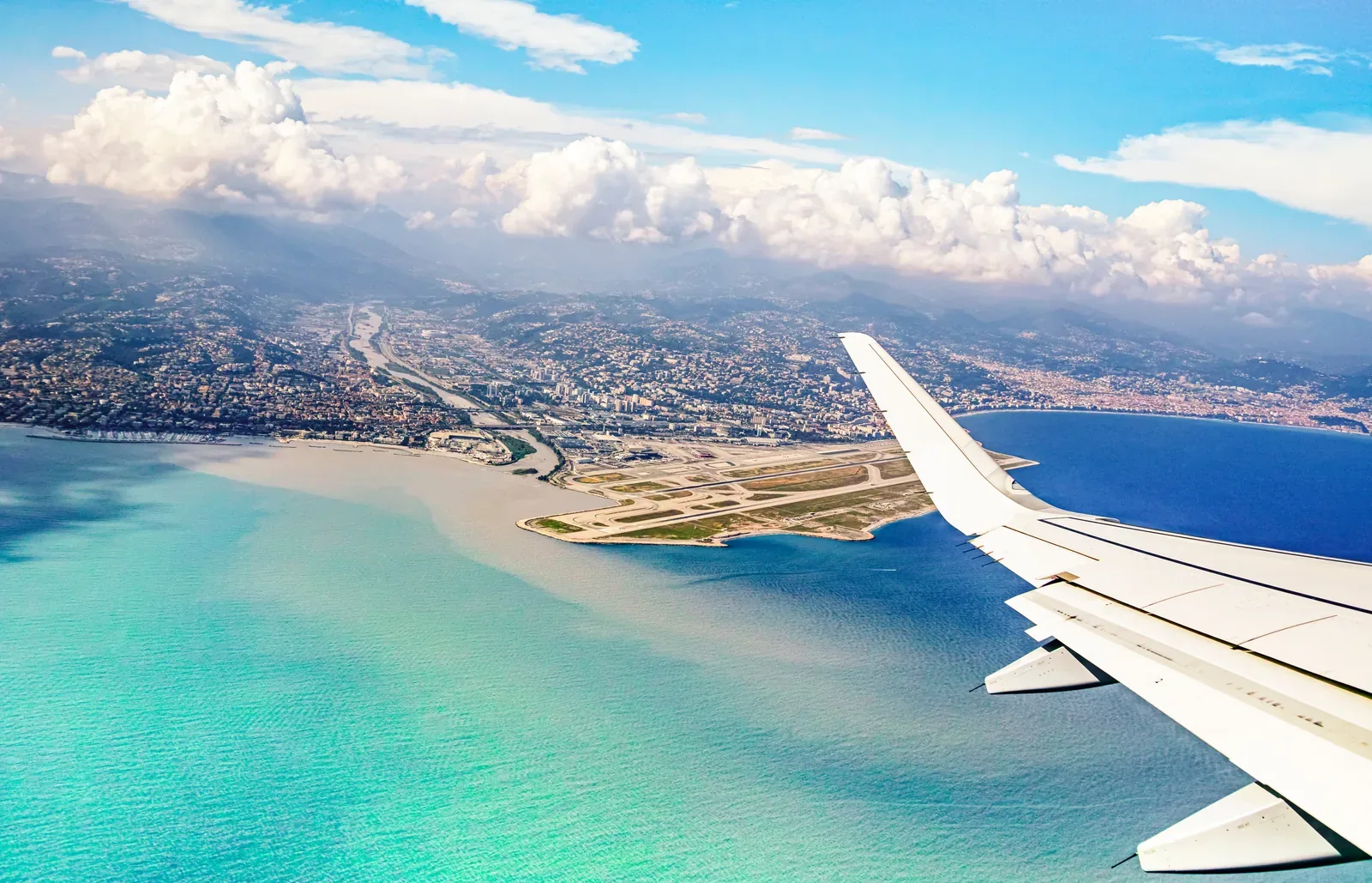 Arrivée en avion au-dessus de Nice, mer turquoise, aéroport et Baie des Anges vus du ciel