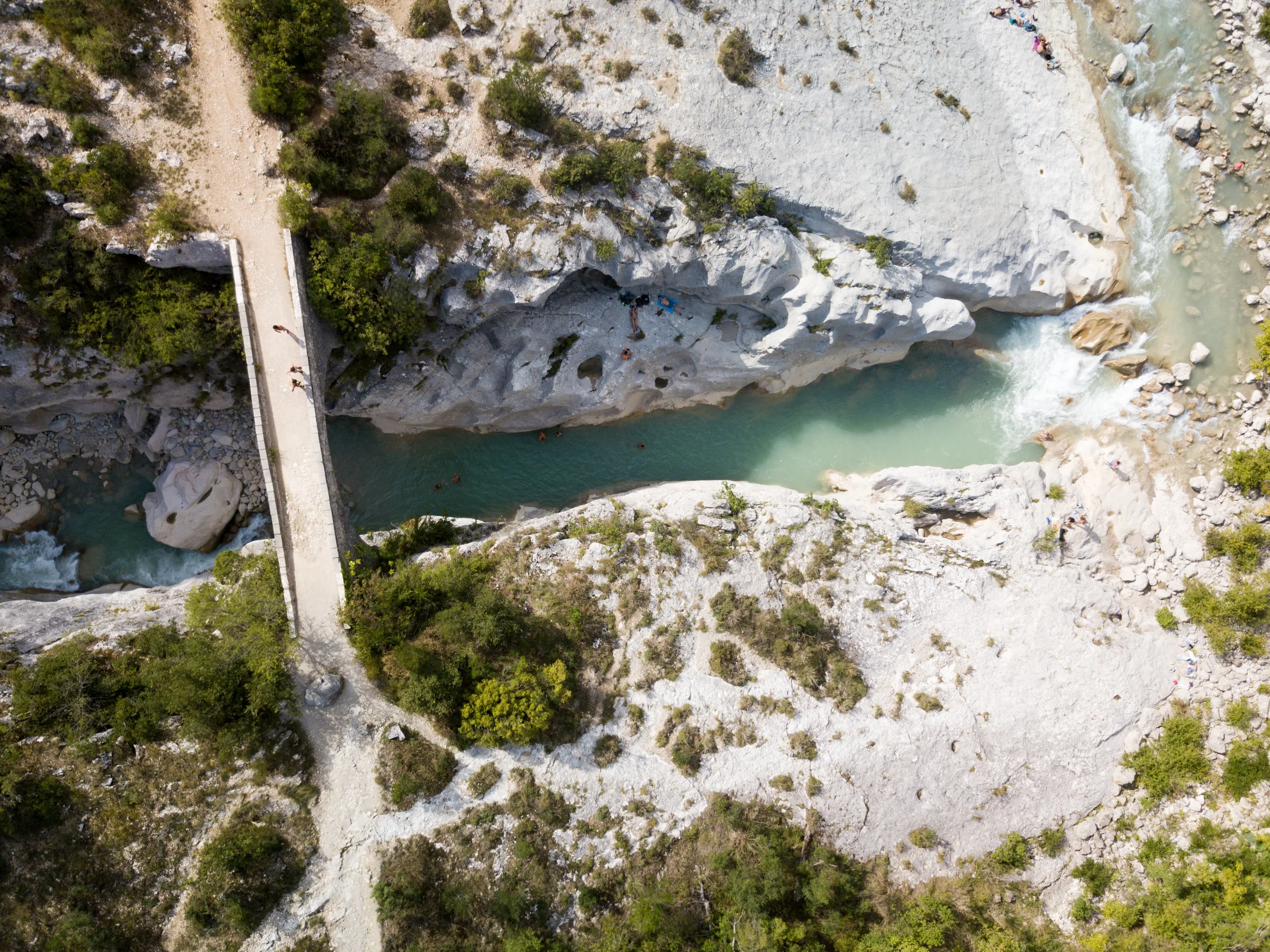 Vue aérienne du pont de la Cerise enjambant les eaux turquoise de l'Estéron, entre falaises blanches