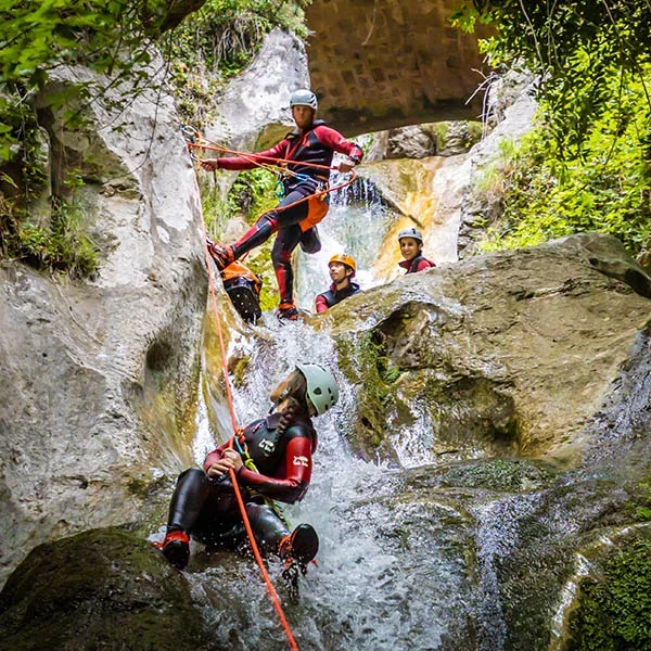Groupe en canyoning descendant en rappel une cascade des gorges du Loup