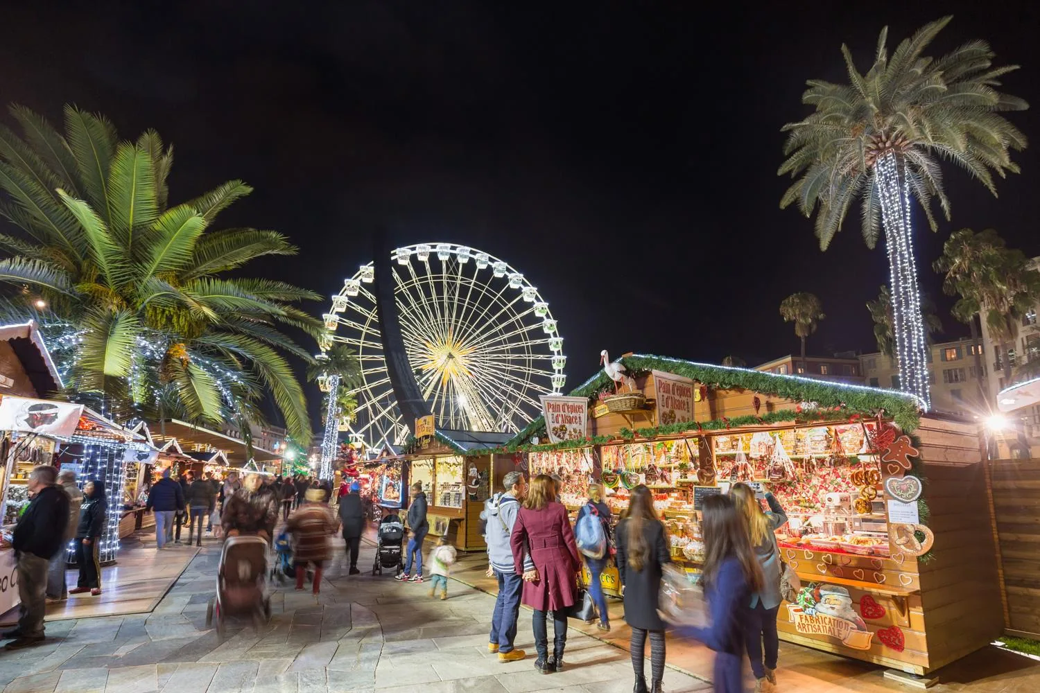 Marché de Noël illuminé sous les palmiers, avec grande roue, à Nice