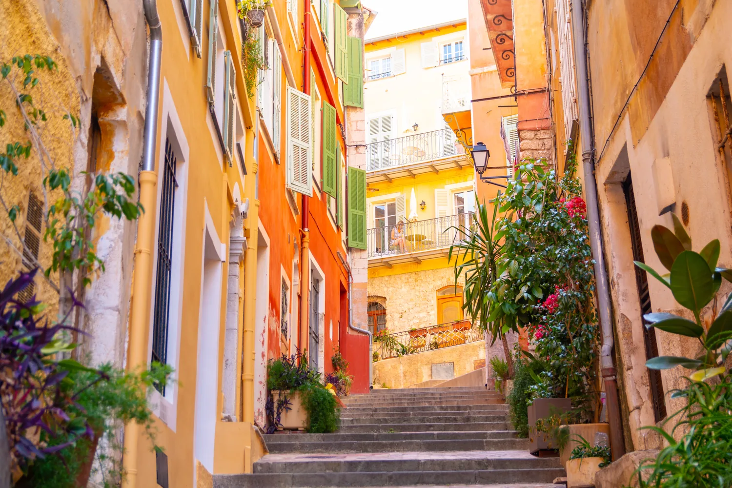 Un escalier étroit et ombragé grimpant entre les façades ocre du Vieux-Nice