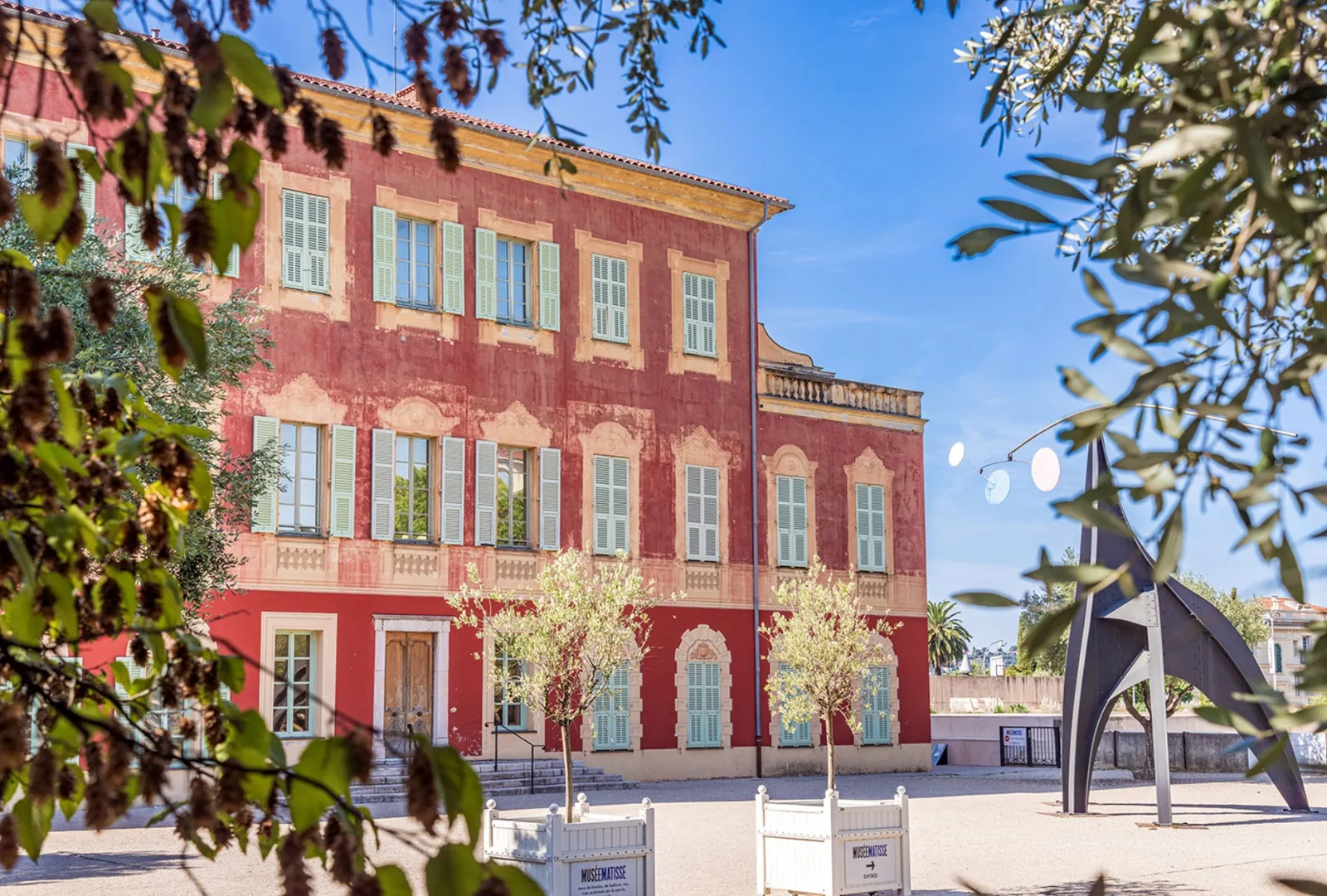 La façade rouge du musée Matisse, dans sa villa génoise entourée d'oliviers à Cimiez