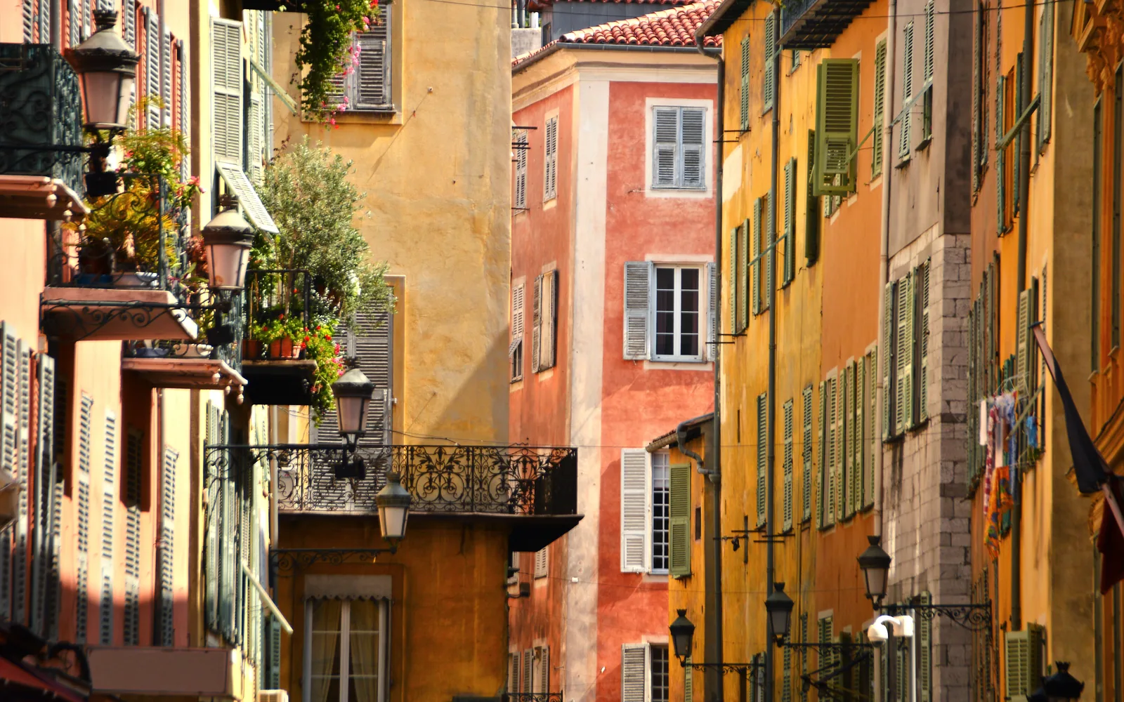 Ruelle du Vieux-Nice aux façades ocre, volets pastel et balcons fleuris