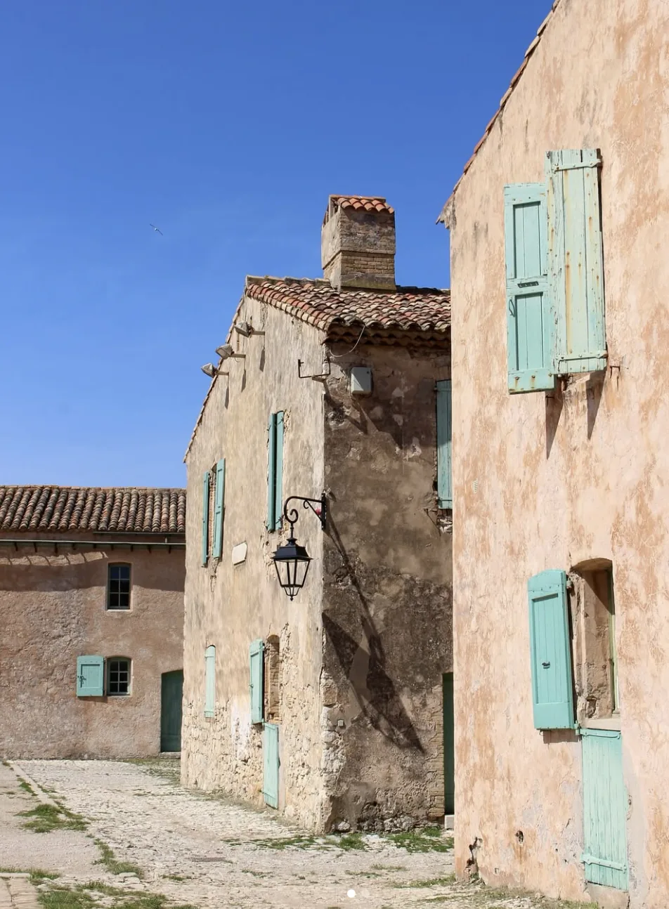 Les facades ocre aux volets turquoise du hameau du Fort Royal